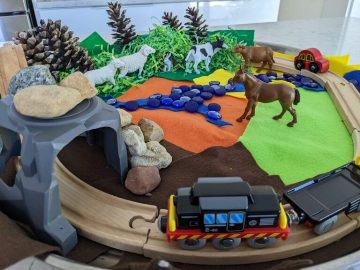 small world set up with cow, horse and train