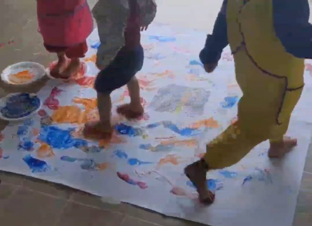 kids painting with feet around kaaba as a Ramadan activity for kids